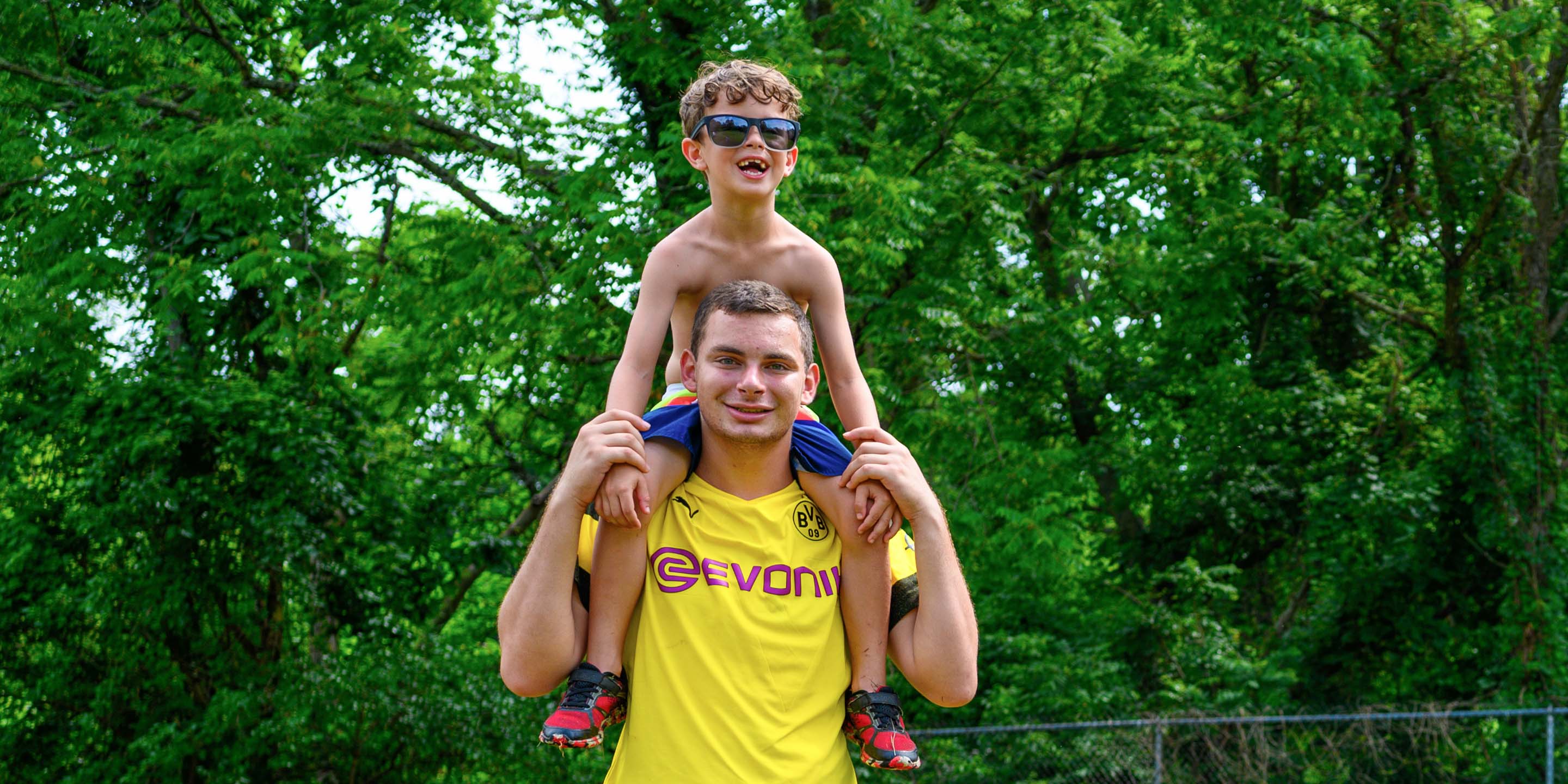 Staff giving camper a piggy back ride