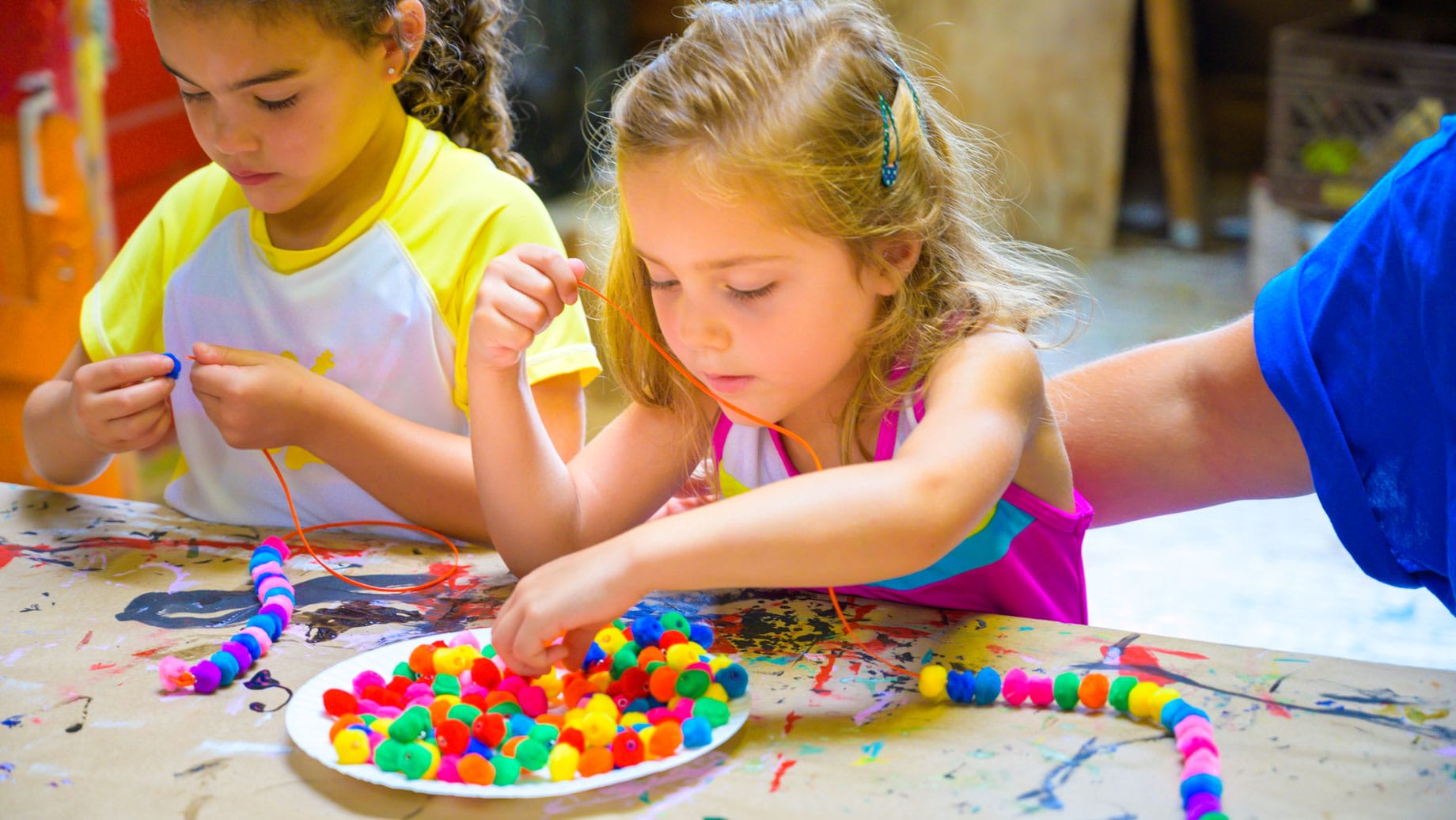 Campers making jewelry at arts and crafts