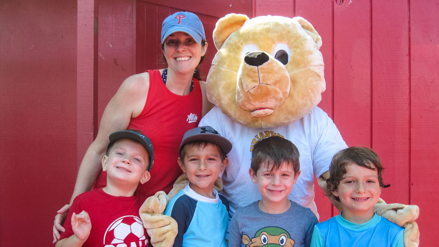 Staff, mascot, and campers smiling