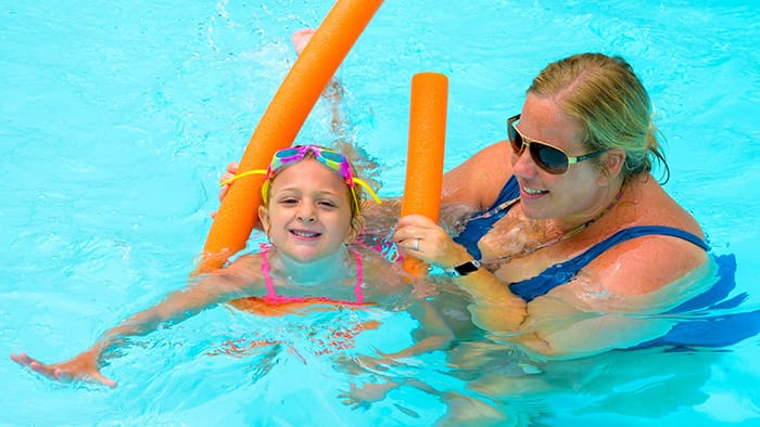 Staff teaching camper how to swim