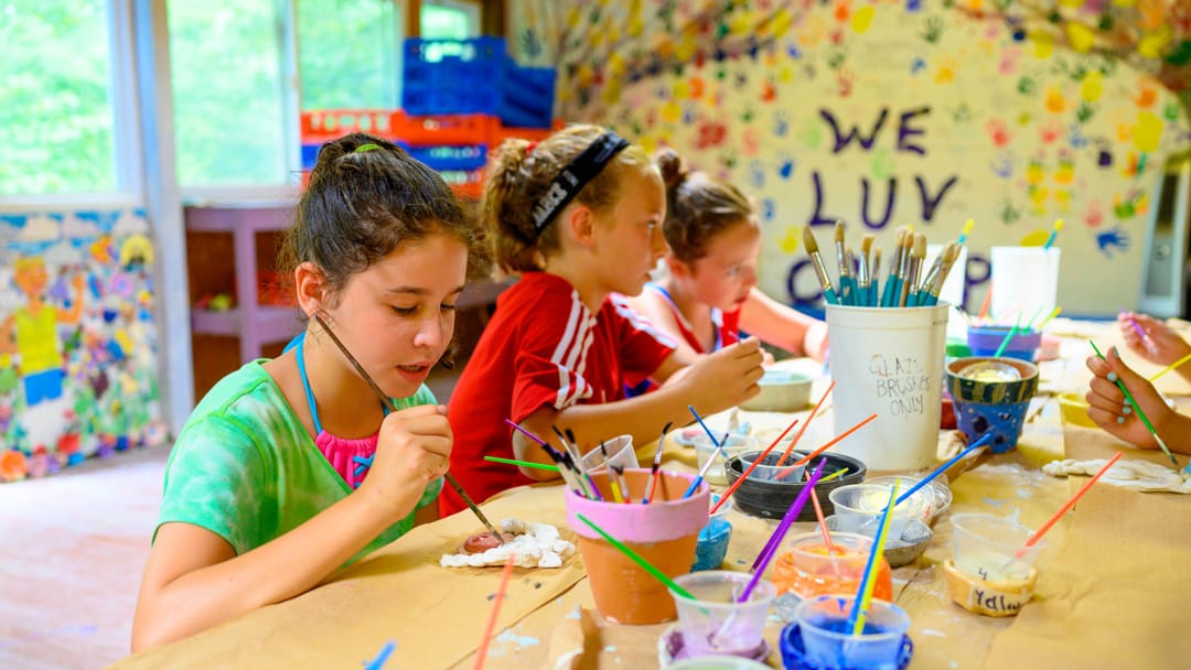 Girls painting at arts and crafts