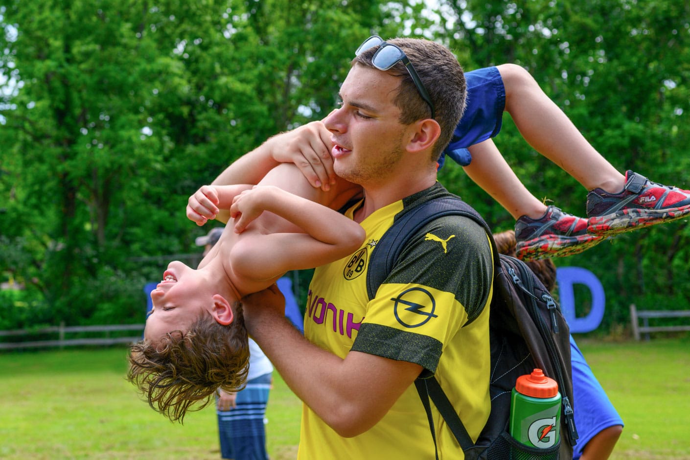 Senior staff lifting camper in air