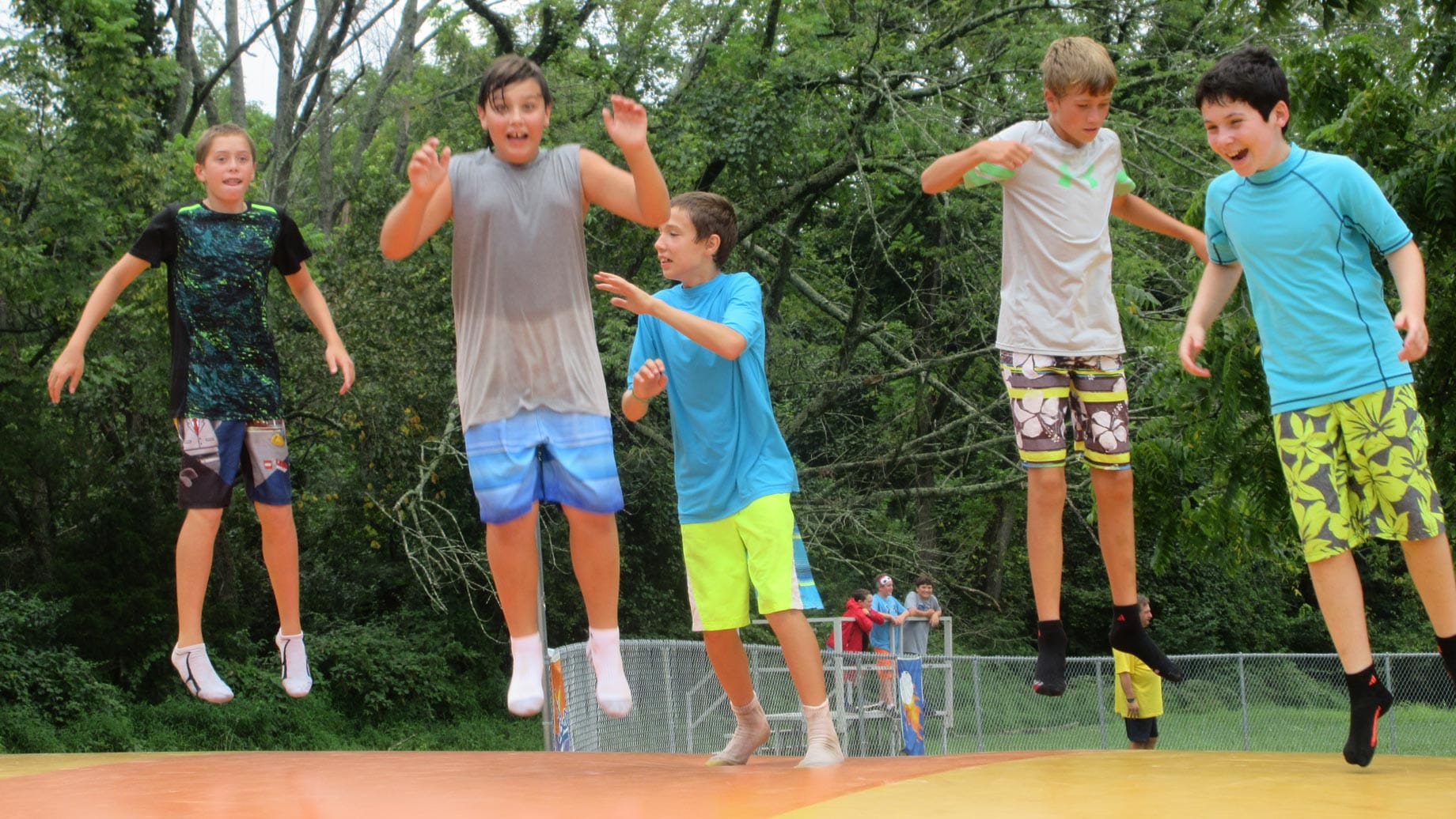 Upper camp boys jumping on giant pillow