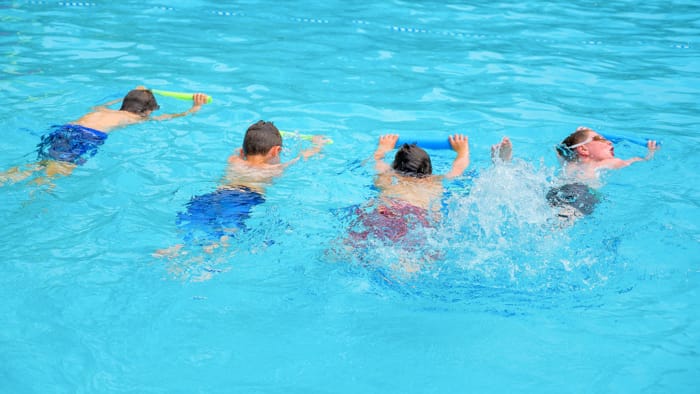 Boys learning to swim in pool