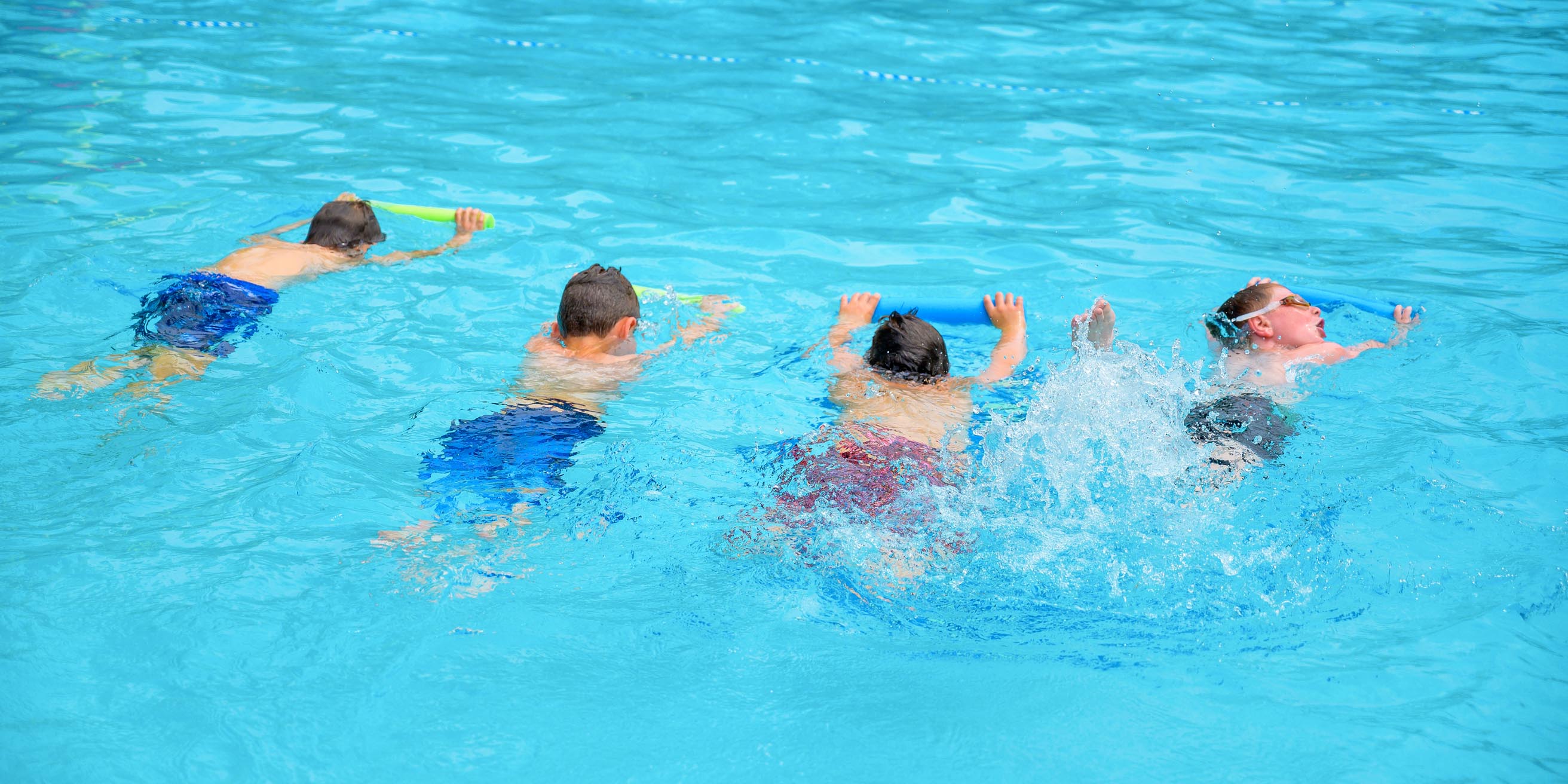 Boys learning to swim in pool