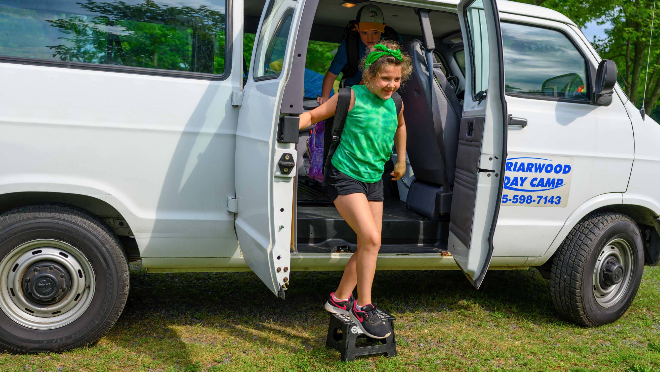 Girl getting out of camp van